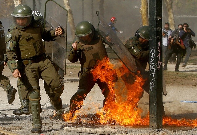 El lado B de la marcha: encapuchados queman auto y lanzan molotov a carabinero El lado B de la marcha: encapuchados queman auto y lanzan molotov a carabinero