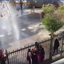 Estudiantes de la UDP se arrodillan delante del carro lanzaaguas en medio de incidentes