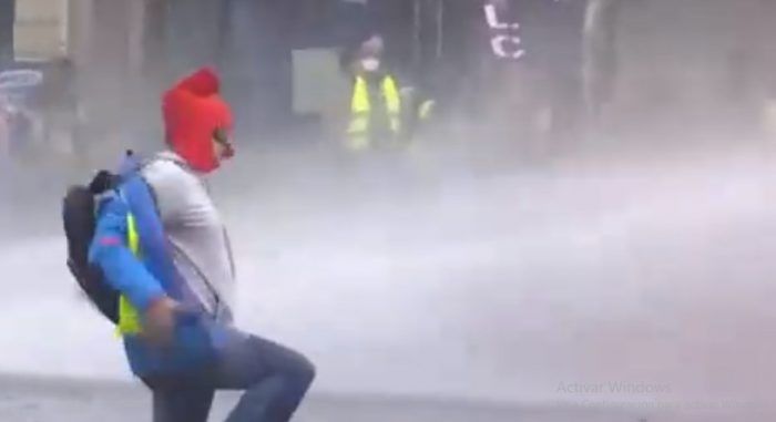 Manifestante en París pone el pecho al agua de carros policiales Manifestante en París pone el pecho al agua de carros policiales