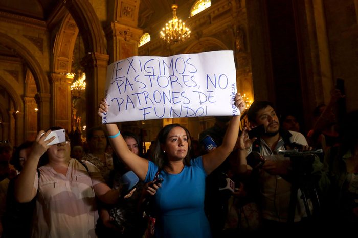 La violenta reacción de un diácono en contra de una mujer que levantó pancarta durante primera misa de Celestino Aós La violenta reacción de un diácono en contra de una mujer que levantó pancarta durante primera misa de Celestino Aós