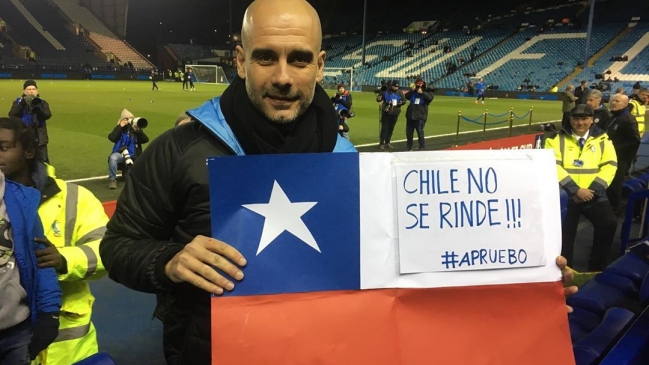 Pep Guardiola posa junto a una bandera con el mensaje: «Chile no se rinde, apruebo» Pep Guardiola posa junto a una bandera con el mensaje: