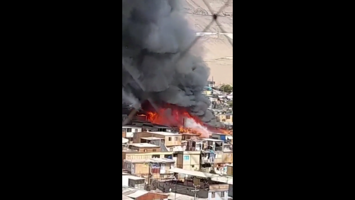 Bomberos trabaja para combatir incendio que afecta a campamento en Iquique Bomberos trabaja para combatir incendio que afecta a campamento en Iquique